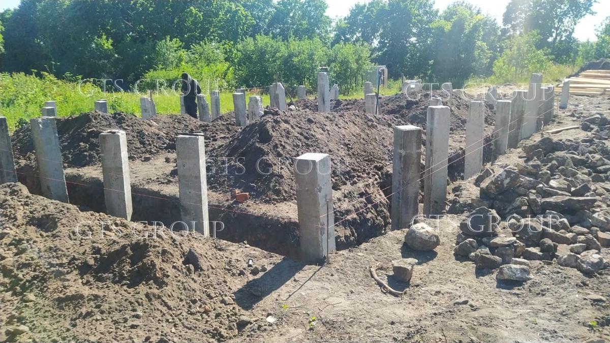 Ряд железобетонных свай по оси наружной стены дома