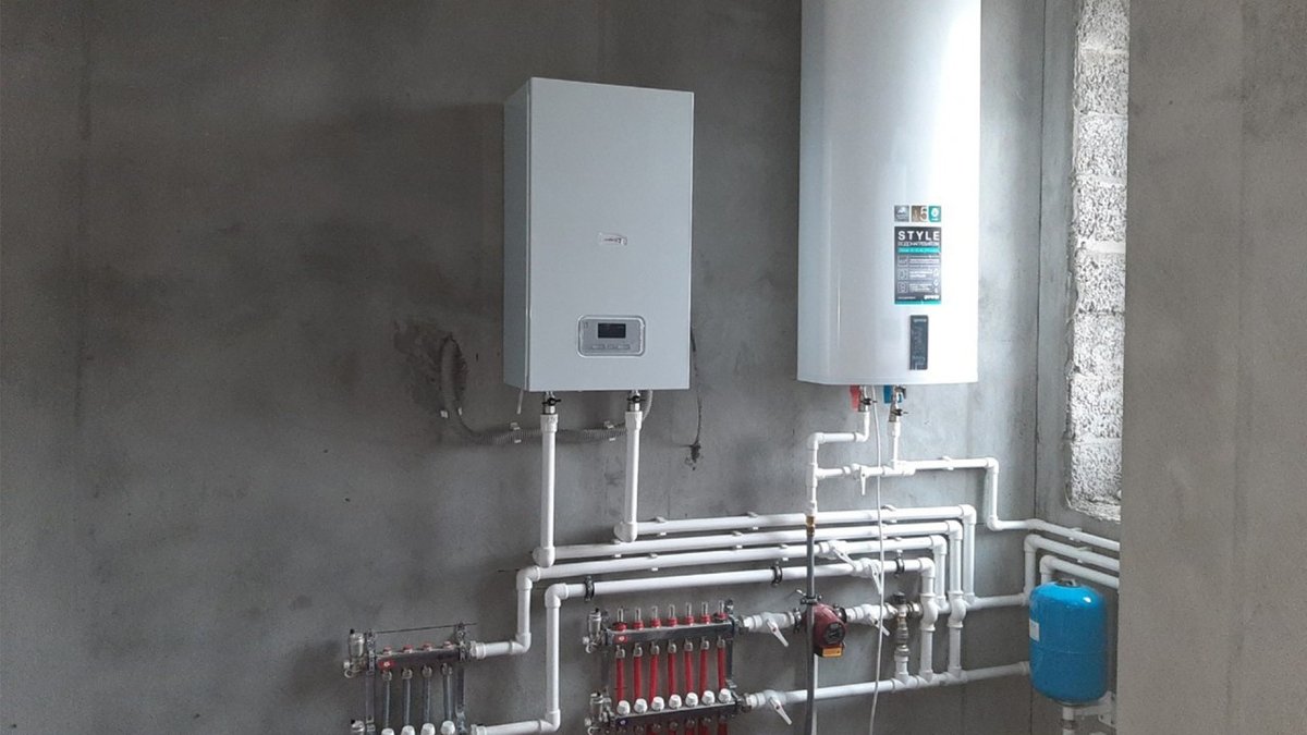 Газовый котёл и водонагреватель на стене из блоков в котельной до отделки