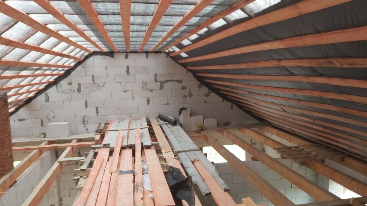 Стропила и мембрана изнутри крыши дома из газобетона